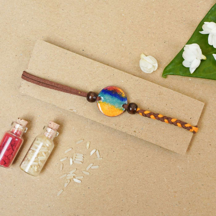 Handmade Indraa Multicolour Copper Enamel Rakhi With Chocolates And Roli Chawal - Bracelet on Kraft Paper Display