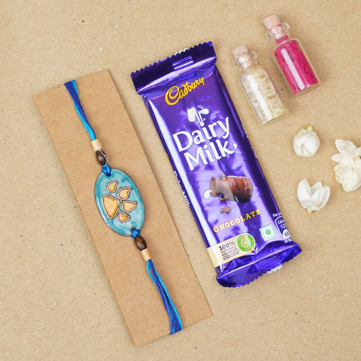 Handmade Pawfect Copper Enamel Rakhi With Chocolates And Roli Chawal - Orange Paw Charm with Gifts