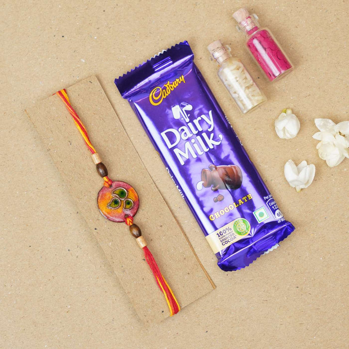 Handmade Morpankh Copper Enamel Rakhi With Chocolates And Roli Chawal - Red bracelet with chocolate gift set
