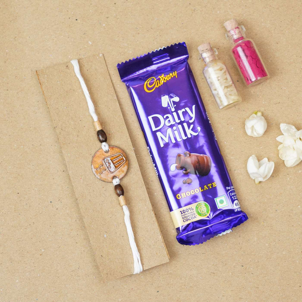 Handmade Chai Paani Brown Copper Enamel Rakhi With Chocolates And Roli Chawal - Product with gift chocolate packaging
