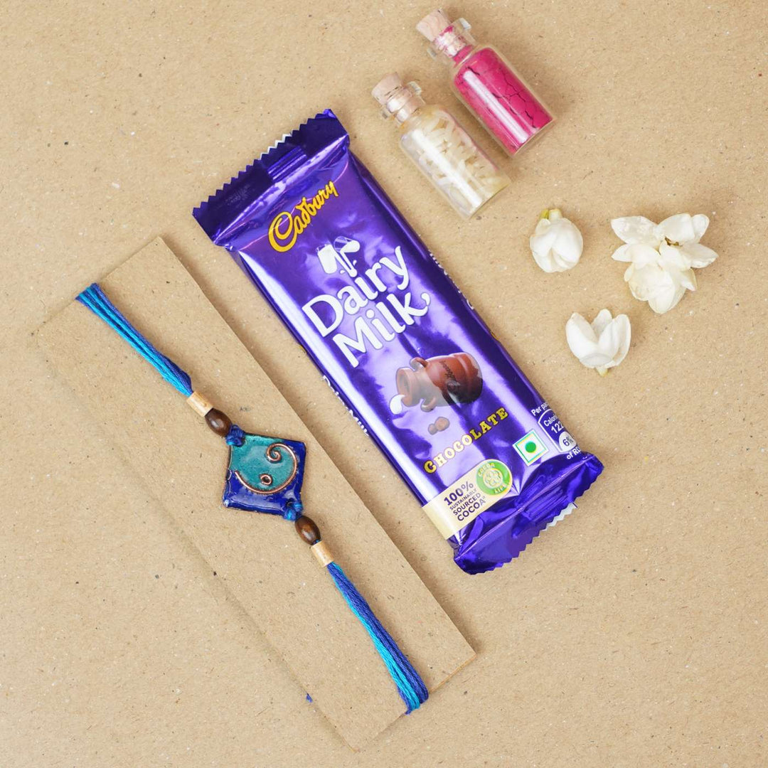Handmade Square Ganesh Copper Enamel Rakhi With Chocolates And Roli Chawal - Blue rakhi with chocolate and accessories