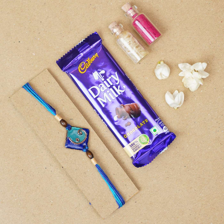 Handmade Square Ganesh Copper Enamel Rakhi With Chocolates And Roli Chawal - Blue rakhi with chocolate and accessories