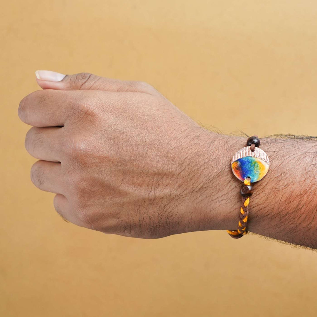 Handmade Indraa Textured Multicolour Copper Enamel Rakhi With Chocolates And Roli Chawal - Worn on wrist display
