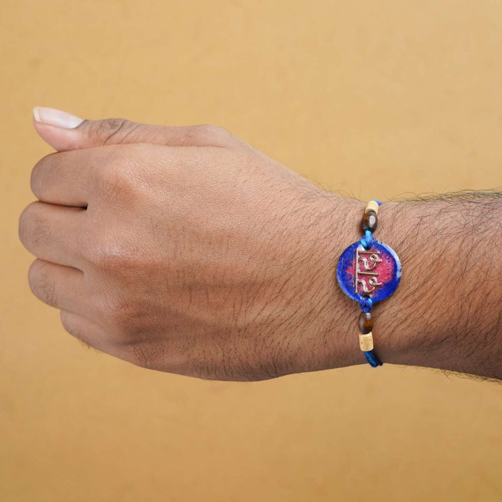 Handmade Dada Blue Copper Enamel Rakhi With Chocolates And Roli Chawal - Rakhi worn on wrist