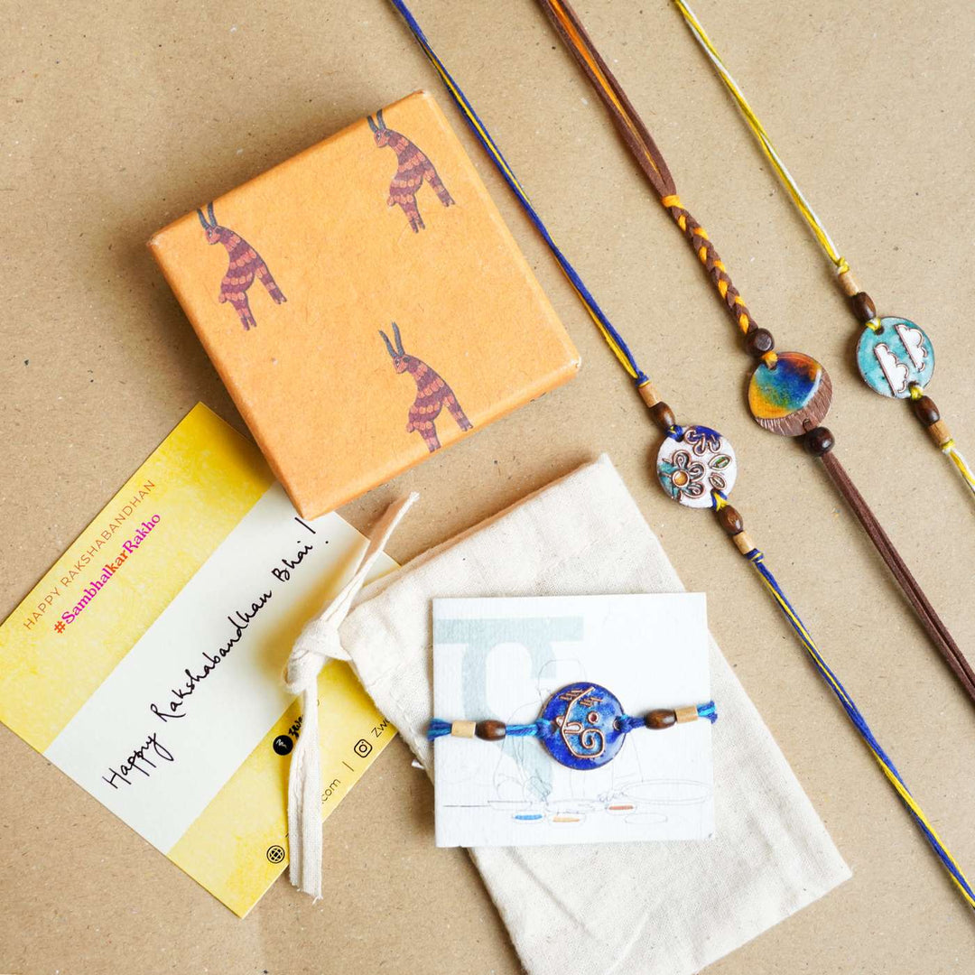 Handmade Square Ganesh Copper Enamel Rakhi With Chocolates And Roli Chawal - Gift set with assorted rakhis and packaging