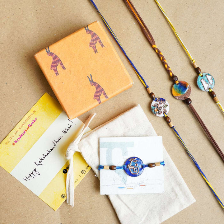 Handmade Square Ganesh Copper Enamel Rakhi With Chocolates And Roli Chawal - Gift set with assorted rakhis and packaging