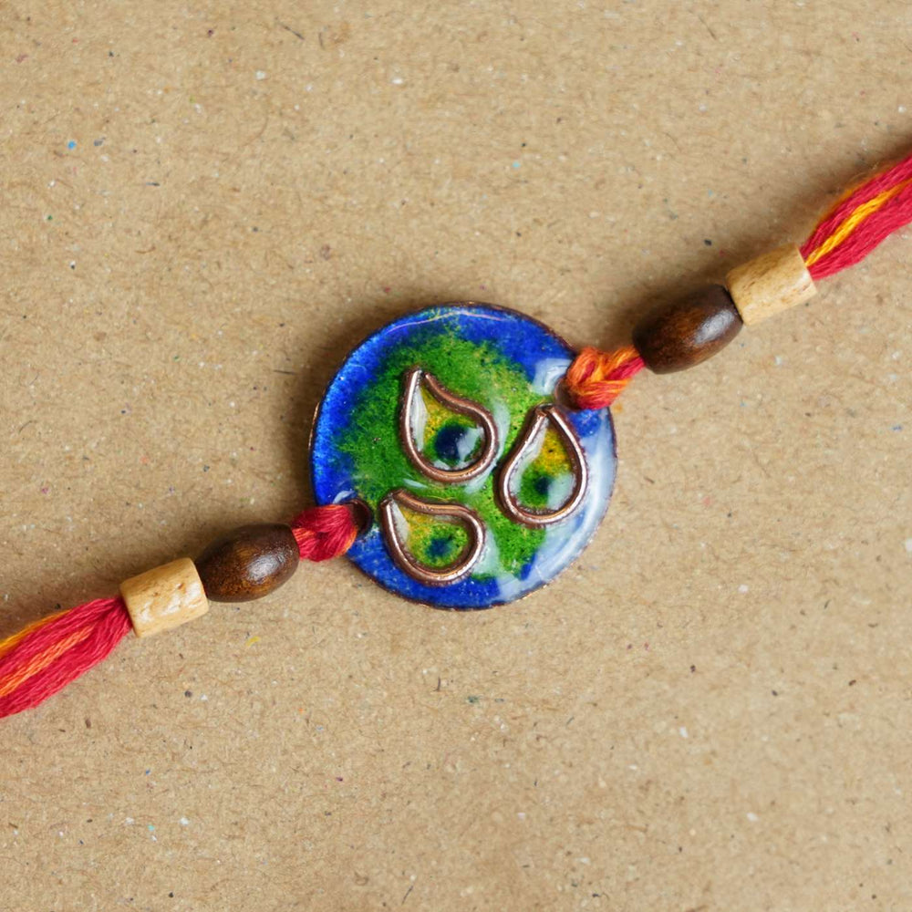 Handmade Morpankh Copper Enamel Rakhi With Chocolates And Roli Chawal - Close-up of blue circular bracelet