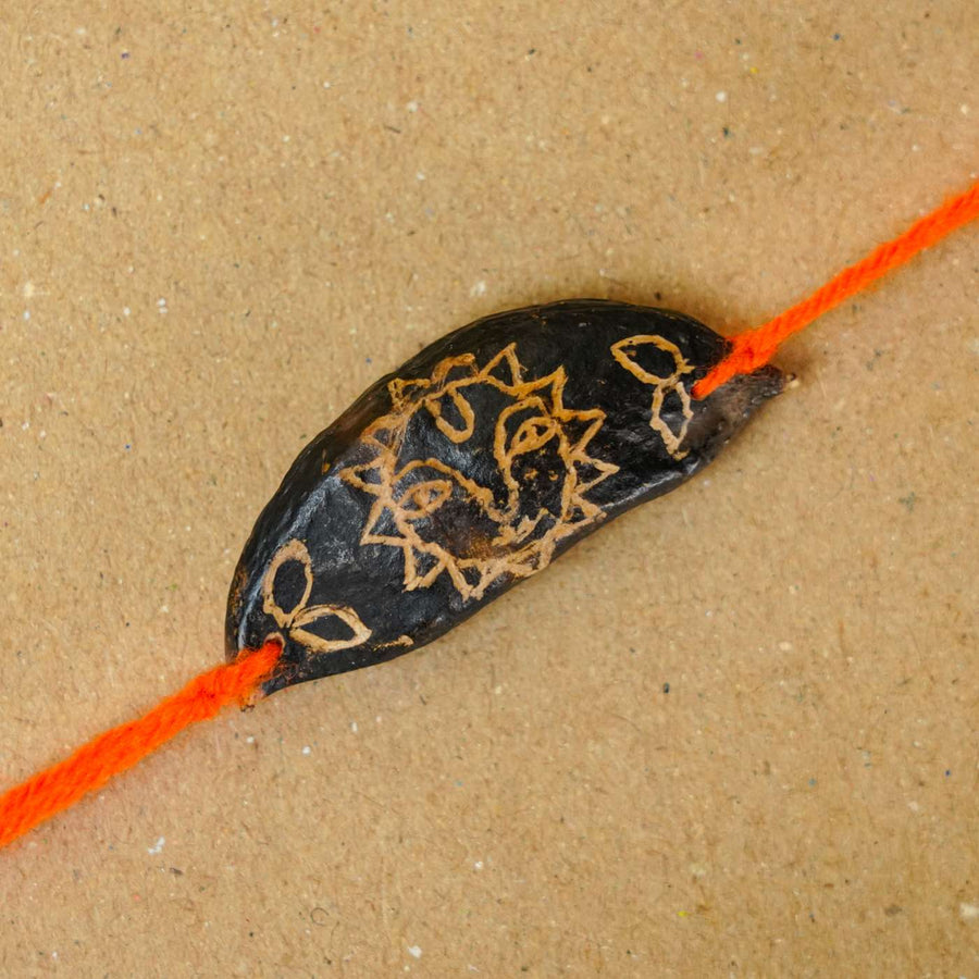 Handmade Plantable Orange Sun Seed Rakhi With Roli Chawal - Close-up of single rakhi piece