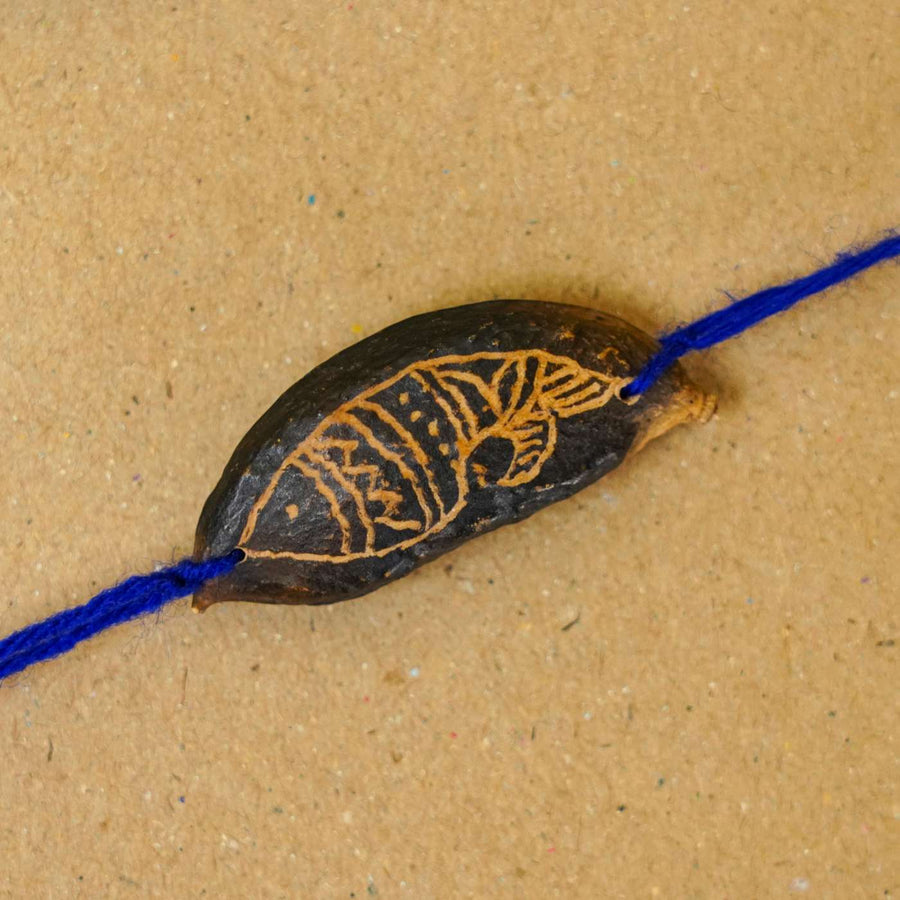 Handmade Plantable Blue Fish Seed Rakhi With Roli Chawal - Close-up of single bracelet bead