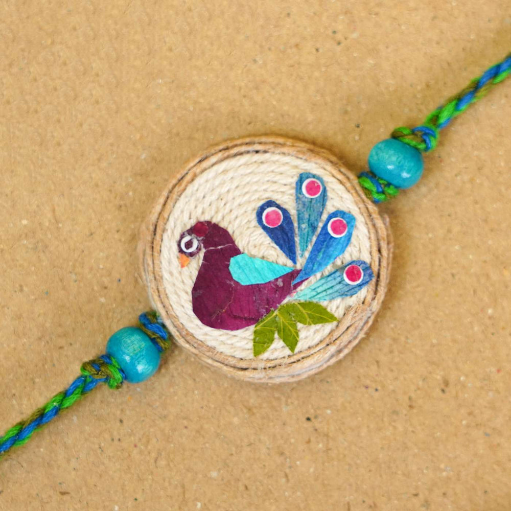 Handmade Pressed Flower Art Peacock Jute Rakhi With Roli Chawal - Close-up of bracelet centerpiece
