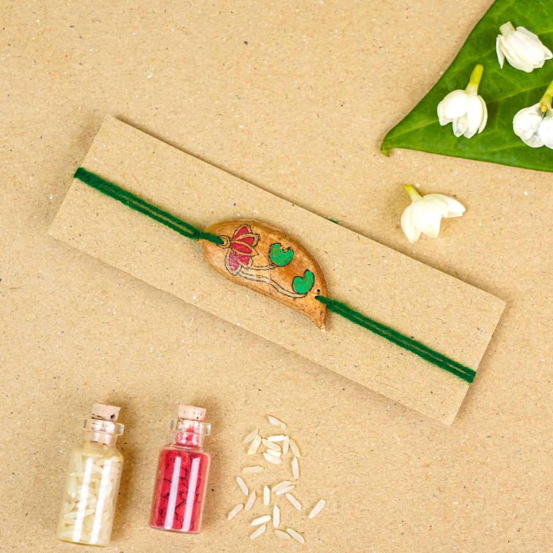 Handmade Plantable Magenta Lotus Seed Rakhi With Roli Chawal - Rakhi tied on display card