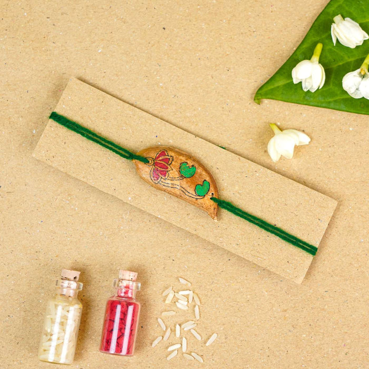 Handmade Plantable Magenta Lotus Seed Rakhi With Roli Chawal - Rakhi tied on display card