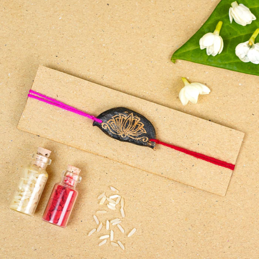 Handmade Plantable Painted Lotus Seed Rakhi With Roli Chawal - Rakhi on display card