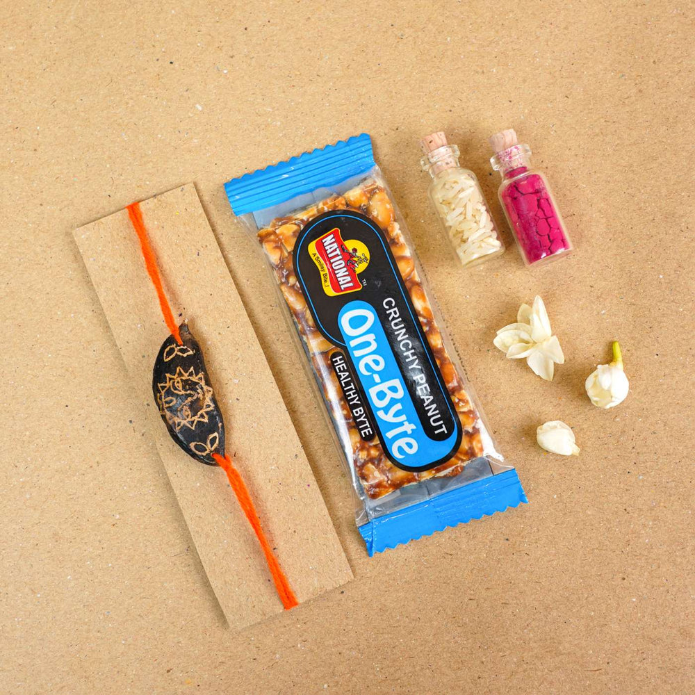 Handmade Plantable Orange Sun Seed Rakhi With Roli Chawal - Flat lay with rakhi and gift items