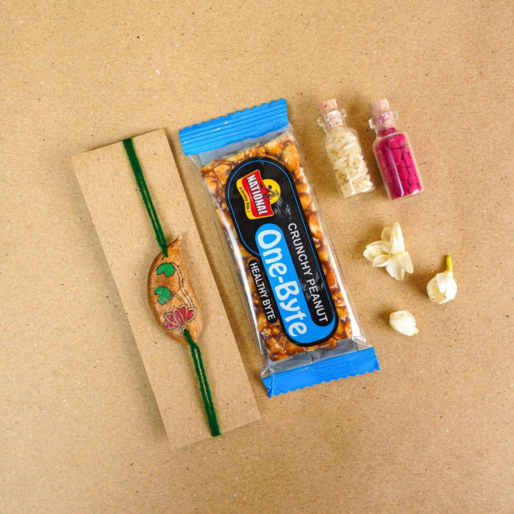 Handmade Plantable Magenta Lotus Seed Rakhi With Roli Chawal - Rakhi with snacks and packaging