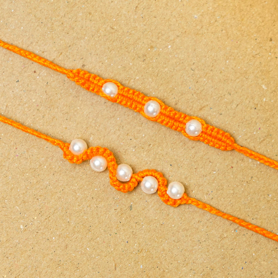 Handmade Macrame Beaded Rakhi With Roli Chawal Set Of 2 1 - Close-up of orange rakhis