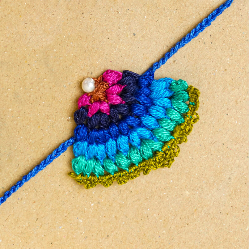 Handmade Crochet Peacock Cotton Rakhi With Roli Chawal - Close-up of Rakhi thread