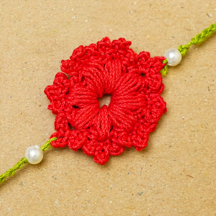 Handmade Crochet Floral Cotton Rakhi With Roli Chawal - Close-up of red Rakhi