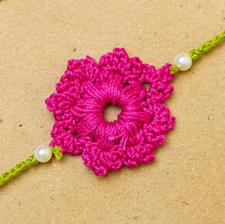 Handmade Crochet Floral Cotton Rakhi With Roli Chawal - Close-up of pink Rakhi