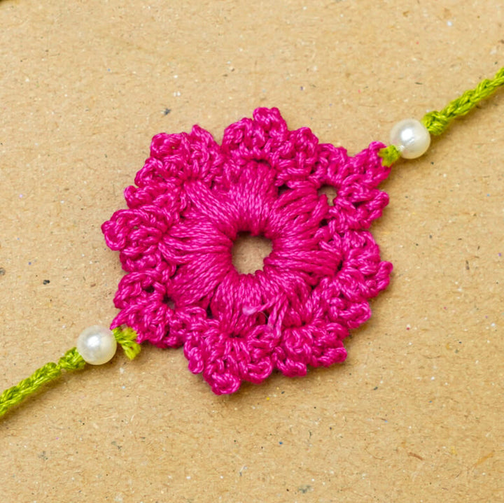 Handmade Crochet Floral Cotton Rakhi With Roli Chawal - Close-up of pink Rakhi