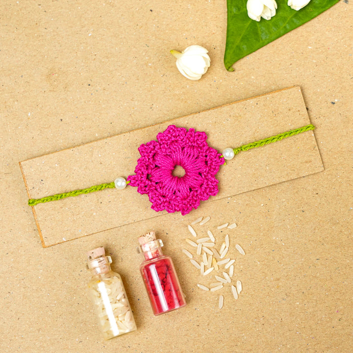 Handmade Crochet Floral Cotton Rakhi With Roli Chawal - Pink Rakhi on packaging board
