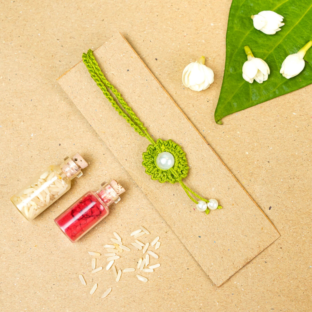 Handmade Crochet Round Pearl Cotton Lumba Rakhi For Bhabhi With Roli Chawal - Flat lay with decorative elements (5)