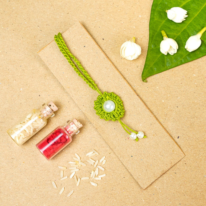 Handmade Crochet Round Pearl Cotton Lumba Rakhi For Bhabhi With Roli Chawal - Flat lay with decorative elements (5)