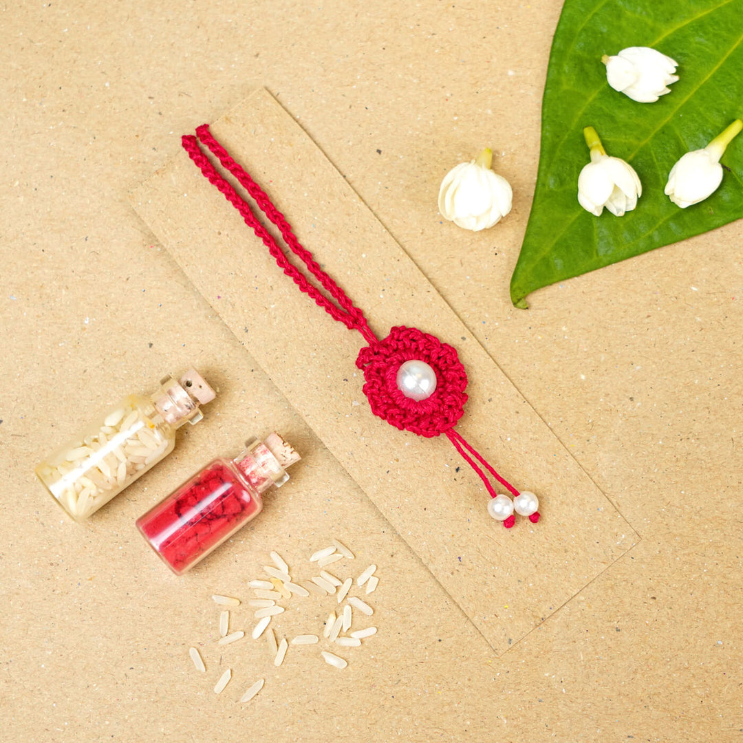 Handmade Crochet Round Pearl Cotton Lumba Rakhi For Bhabhi With Roli Chawal - Flat lay with decorative elements (13)