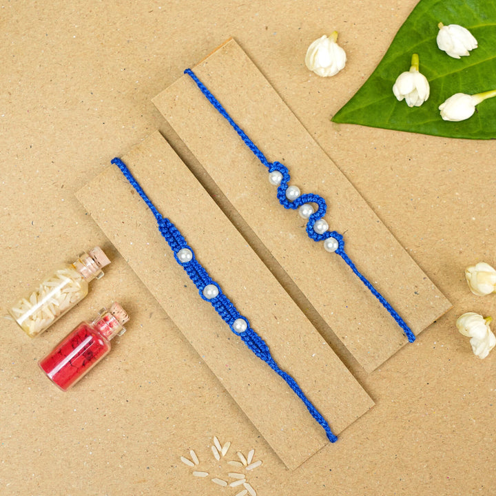 Handmade Macrame Beaded Rakhi With Roli Chawal Set Of 2 1 - Blue rakhis on cardboard