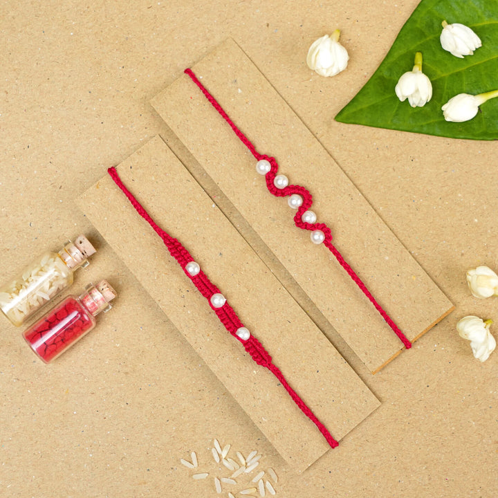 Handmade Macrame Beaded Rakhi With Roli Chawal Set Of 2 1 - Red rakhis on cardboard