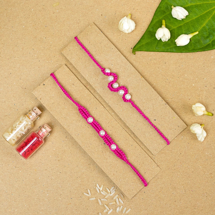 Handmade Macrame Beaded Rakhi With Roli Chawal Set Of 2 1 - Pink rakhis on cardboard