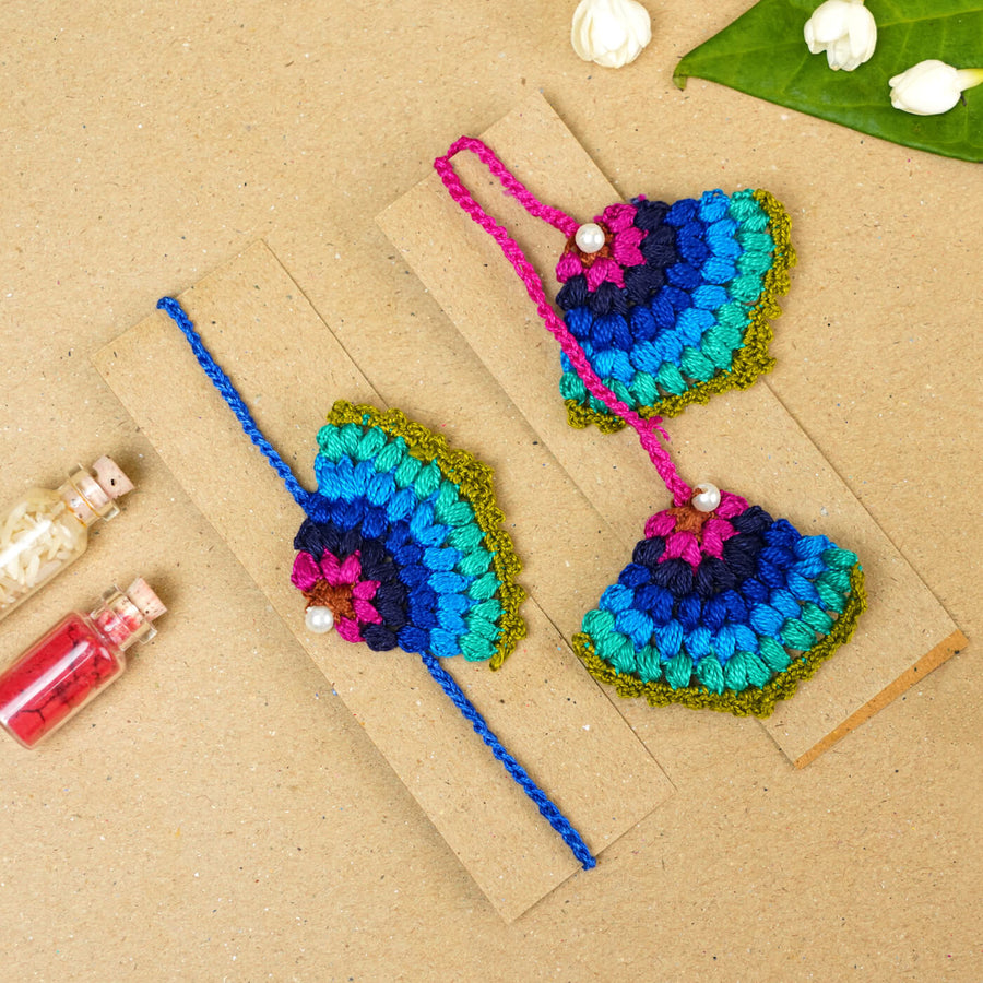 Handmade Crochet Peacock Cotton Bhaiya Bhabhi Rakhi With Roli Chawal Set Of 2 - Pair Displayed on Cardboard
