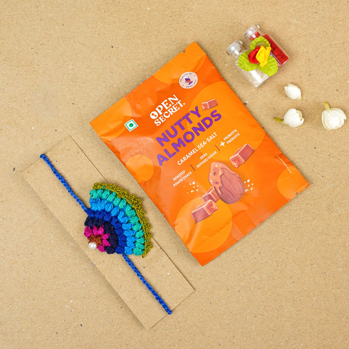Handmade Crochet Peacock Cotton Rakhi With Roli Chawal - Size comparison with snack pack