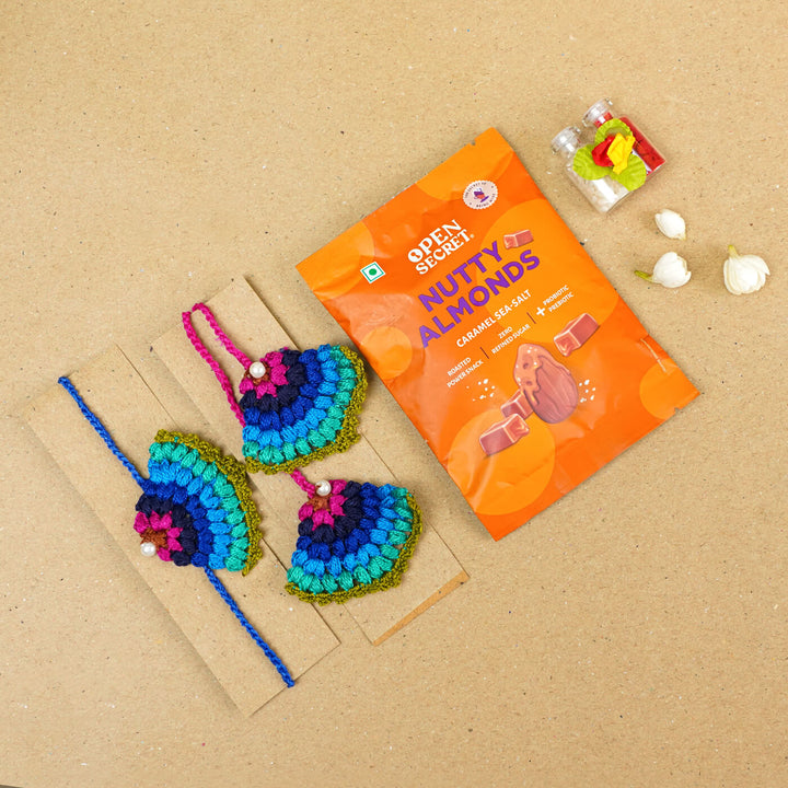 Handmade Crochet Peacock Cotton Bhaiya Bhabhi Rakhi With Roli Chawal Set Of 2 - Displayed with Gift Item