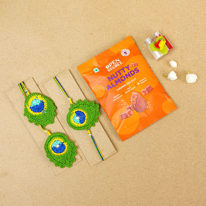 Handmade Crochet Peacock Feather Cotton Bhaiya Bhabhi Rakhi With Roli Chawal Set Of 2 - Front view with gift packaging