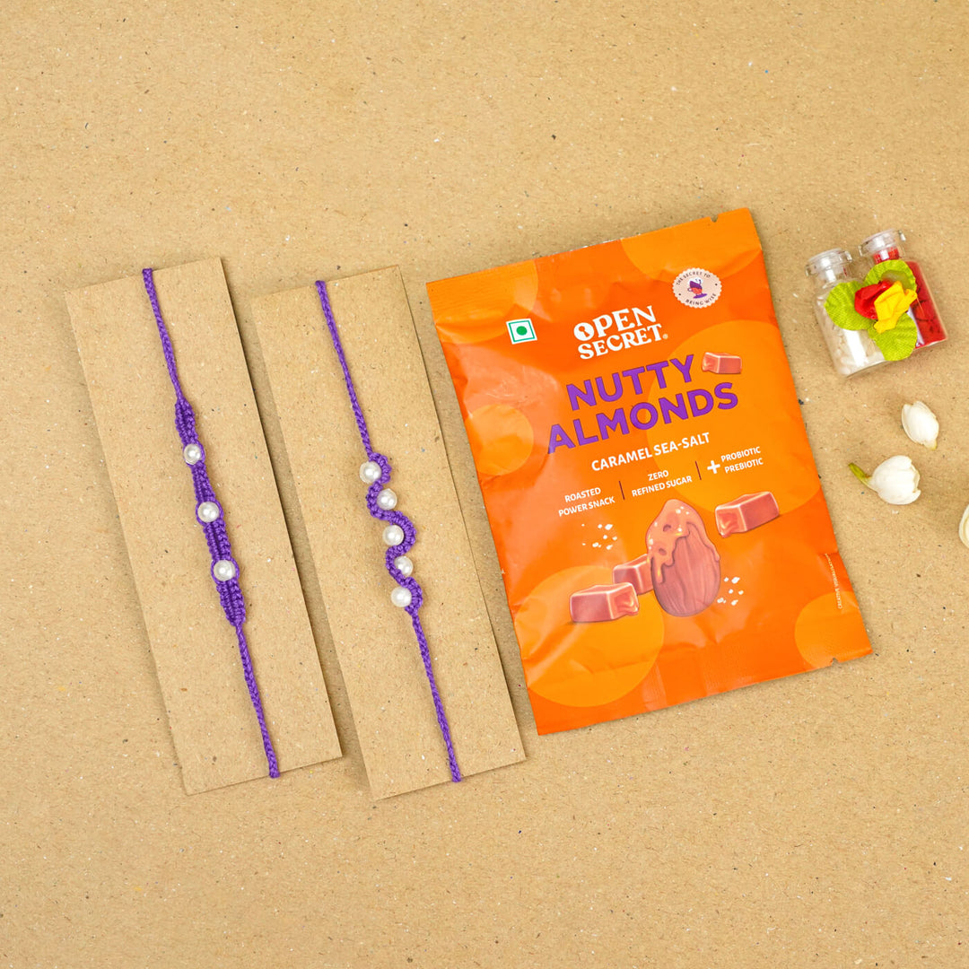 Handmade Macrame Beaded Rakhi With Roli Chawal Set Of 2 1 - Purple rakhis on cardboard