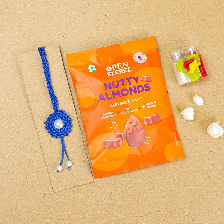 Handmade Crochet Round Pearl Cotton Lumba Rakhi For Bhabhi With Roli Chawal - Flat lay with snack pack