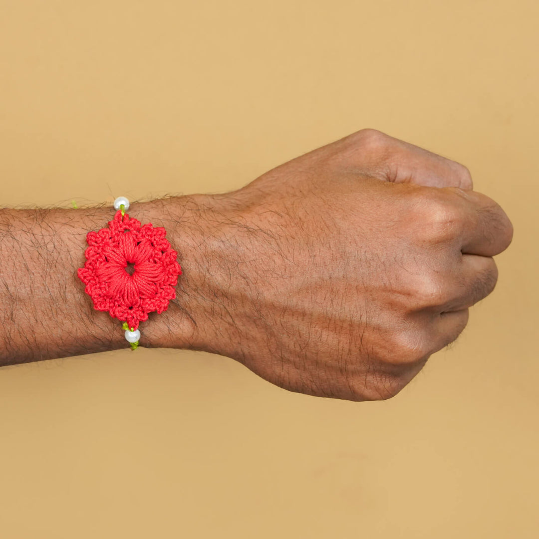 Handmade Crochet Floral Cotton Rakhi With Roli Chawal - Red Rakhi worn on wrist