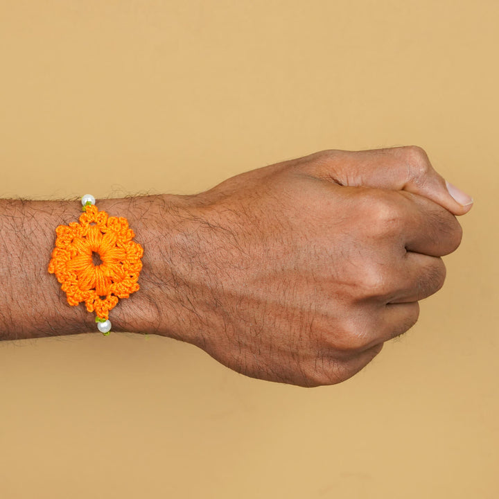 Handmade Crochet Floral Cotton Rakhi With Roli Chawal - Orange Rakhi worn on wrist