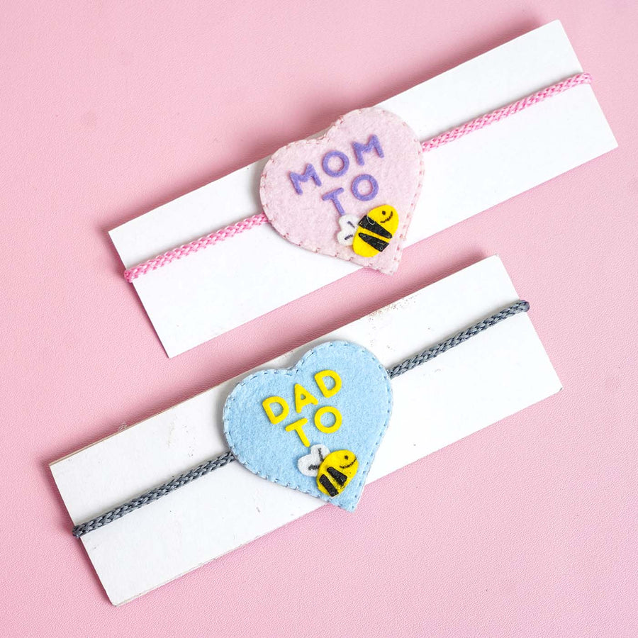 Personalized Handmade Felt Mom Dad To Be Rakhi With Roli Chawal Set Of 2 - Front View on Display Card