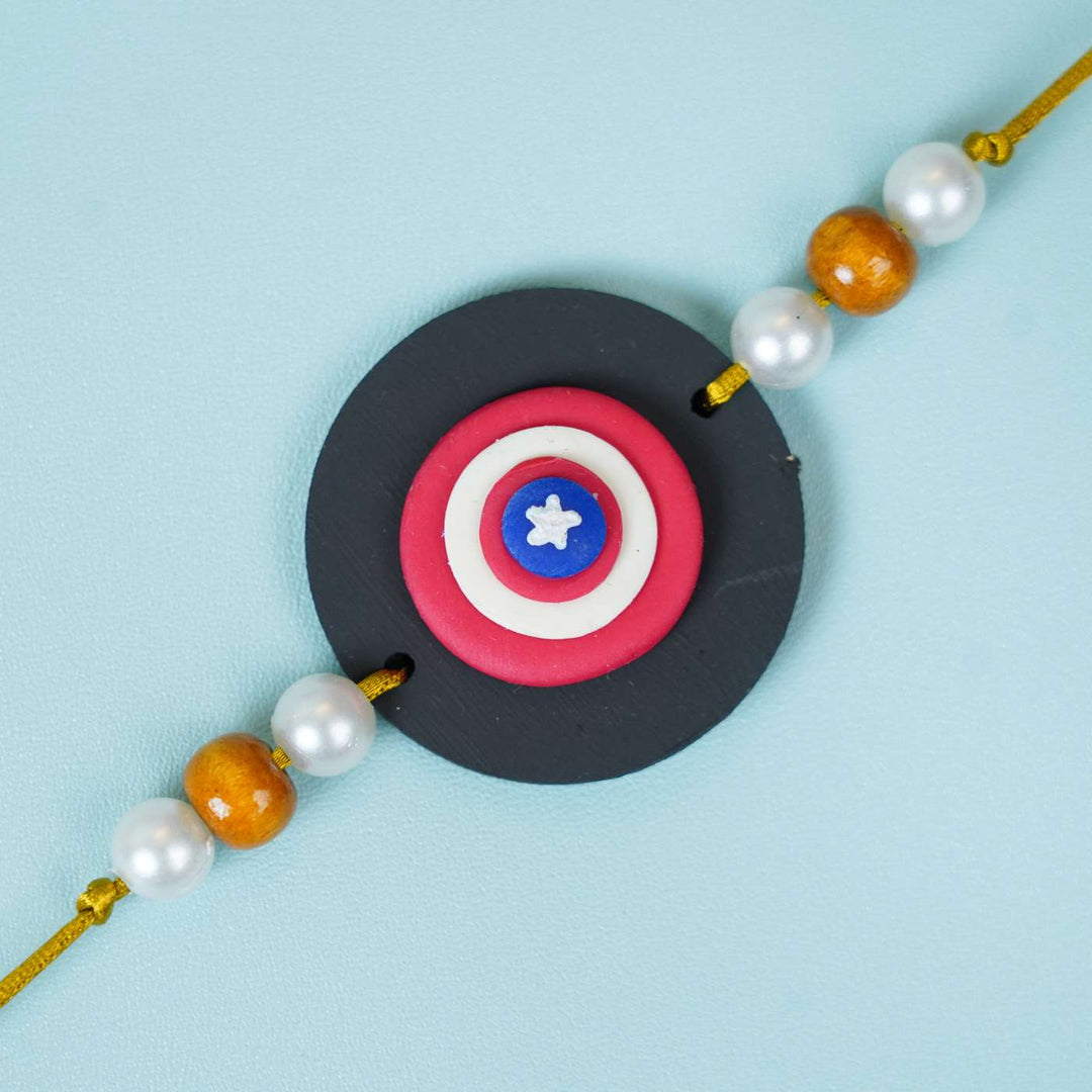 Handmade Miniature Clay Captian America Kids Rakhi With Roli Chawal - Close-up of Charm Detail