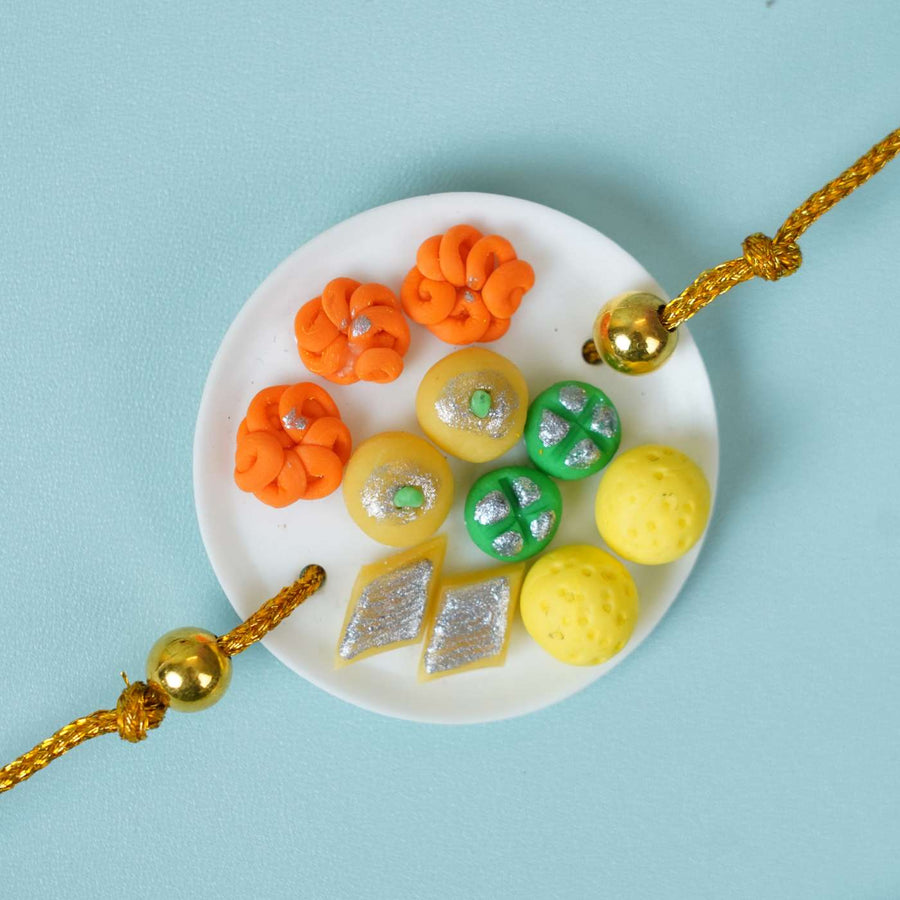 Handmade Miniature Clay Traditional Sweets Rakhi With Roli Chawal - Close-up of Rakhi plate charms