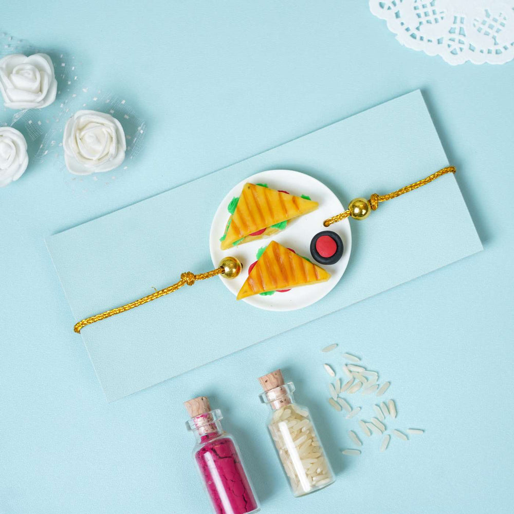 Handmade Miniature Clay Sandwich Rakhi With Roli Chawal - Top view with decorative props
