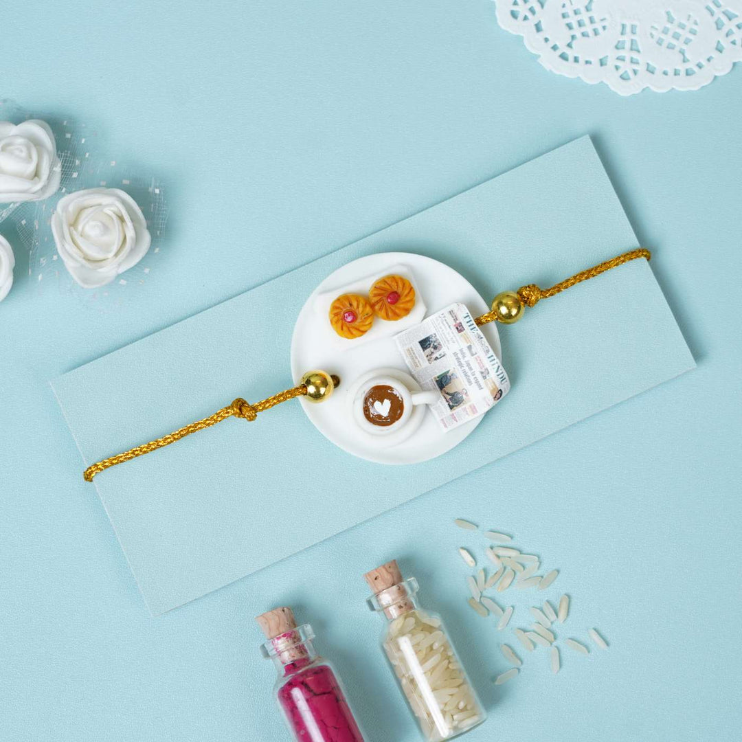 Handmade Miniature Clay Coffee Rakhi With Roli Chawal - Bracelet on envelope, styled display