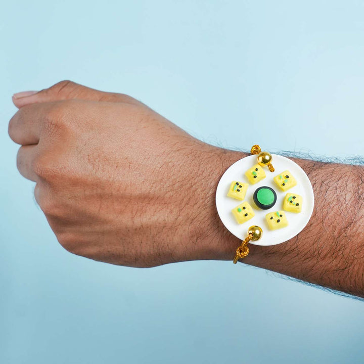 Handmade Miniature Clay Dhokla Rakhi With Roli Chawal - Rakhi worn on wrist
