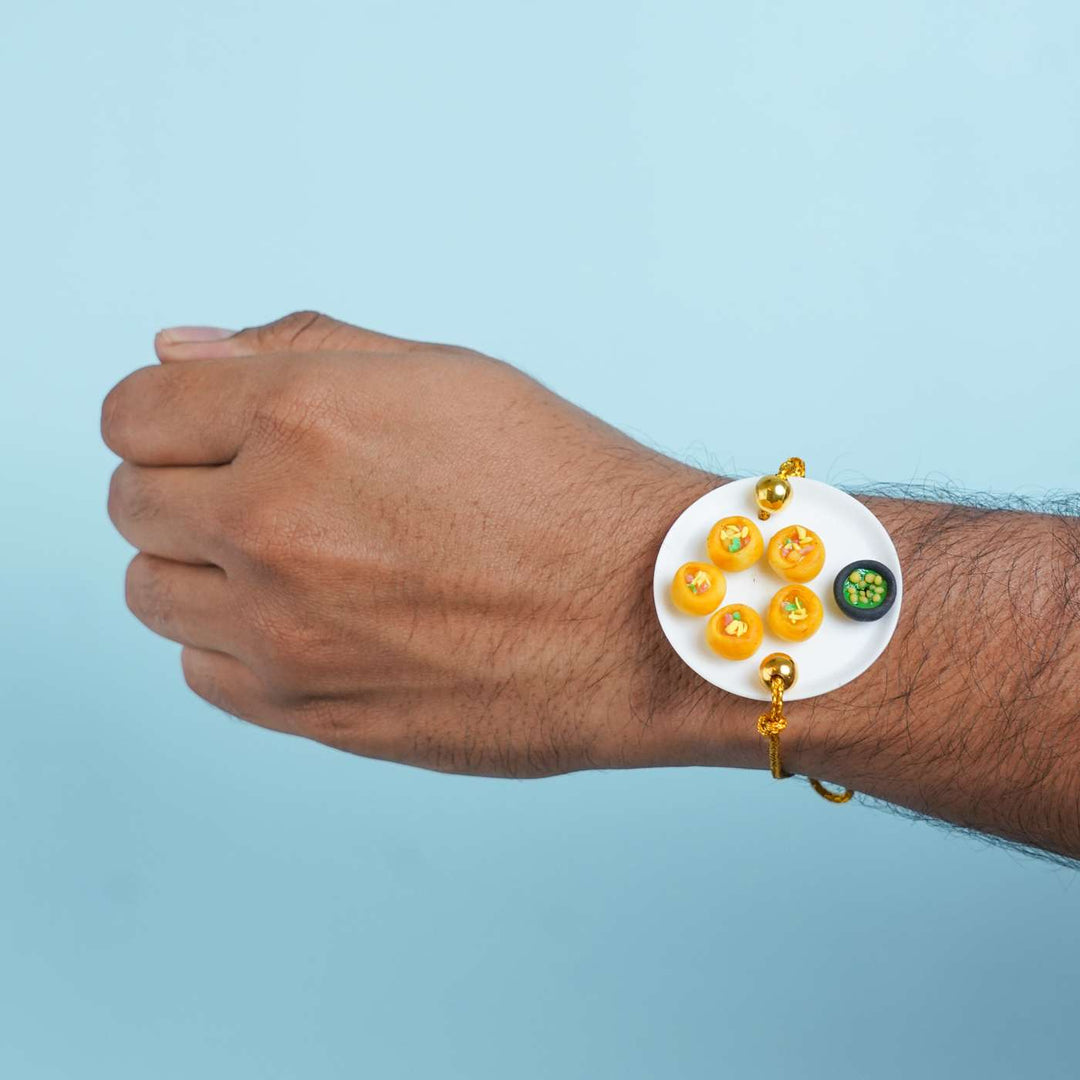 Handmade Miniature Clay Pani Puri Rakhi With Roli Chawal - Wrist shot showing Rakhi wear