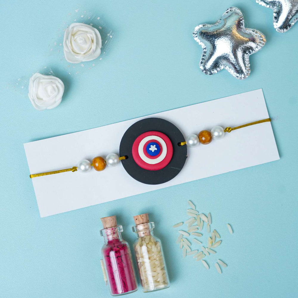 Handmade Miniature Clay Captian America Kids Rakhi With Roli Chawal - Flat Lay on Display Card