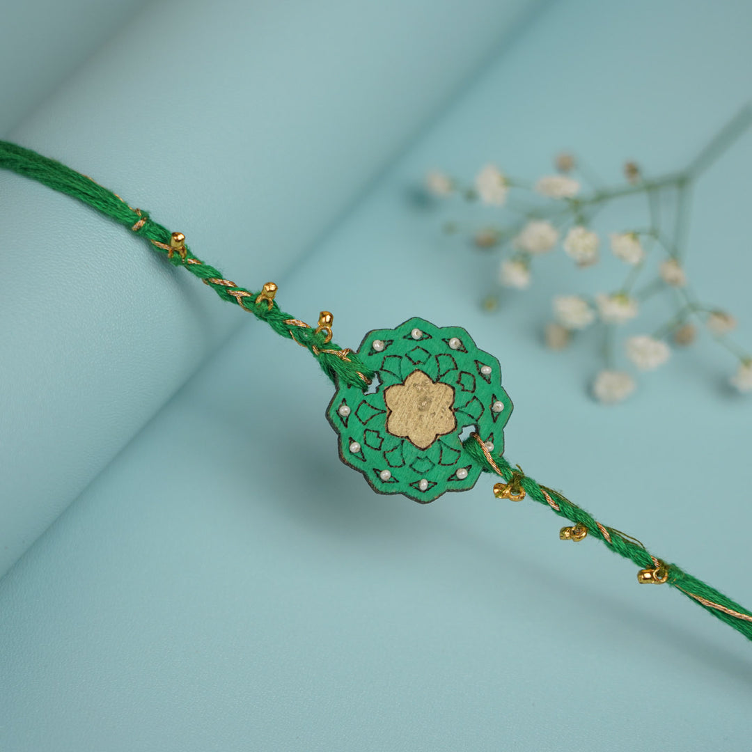 Handmade Green Flower Shape Ghungroo And Shell Wooden Bhaiya Bhabhi Rakhi With Roli Chawal - Close-up of Circular Detail