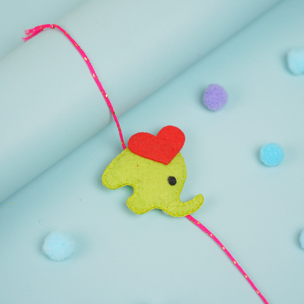 Customized Handmade Beaded Elephant Theme Pom Pom Felt Rakhi With Roli Chawal For Kids - Close-up of Green Elephant Charm