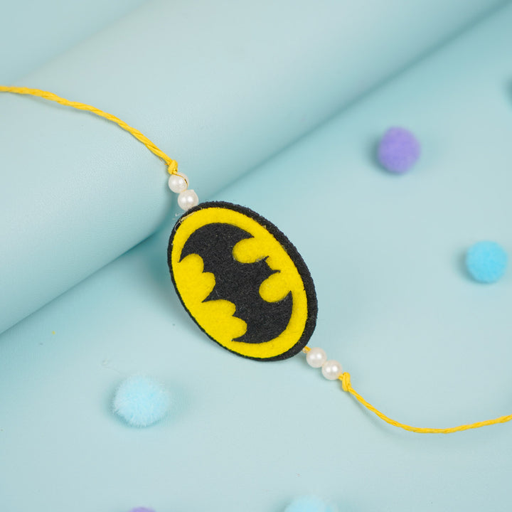 Handmade Beaded Batman Theme Pom Pom Felt Rakhi With Roli Chawal For Kids - Close-up Angled View